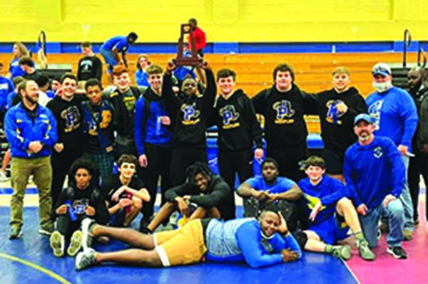 Coach Josh White (at left) and members of the Palatka High School wrestling team gather for a team picture after winning the District 5-1A championship on Wednesday. (Palatka High School Wrestling photo)