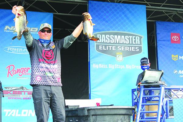 Palatka’s Cliff Prince shows off two of his catches during Saturday’s AFTCO Bassmaster Elite At St. Johns River event to the crowd at the Palatka Docks. (MARK BLUMENTHAL / Palatka Daily News)