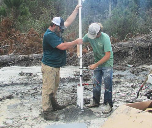 Dennis Layman and Austin Layman of Layman Well Drilling work on a well system at the site of a new house at Nobles Crossing.