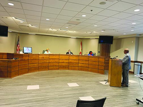 Assistant Superintendent of Support Services Thomas Bolling addresses Putnam County School District board members Wednesday afternoon about changes to the district’s revitalization plans. Board member Jane Crawford appeared on a monitor.