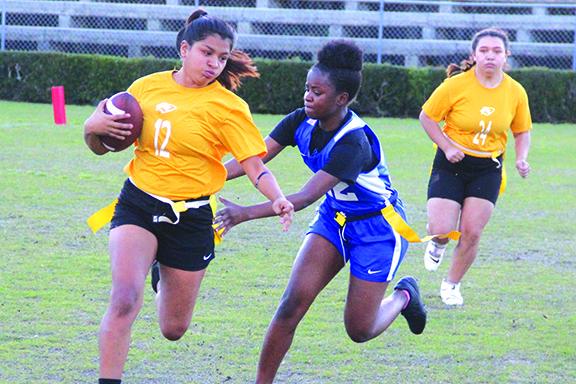 Crescent City’s Isabella Torres (12) looks to avoid the flag-pull attempt of Palatka’s Samaria Williams. Crescent City’s Jasmine Vidana is in the background. (ANTHONY RICHARDS / Palatka Daily News)