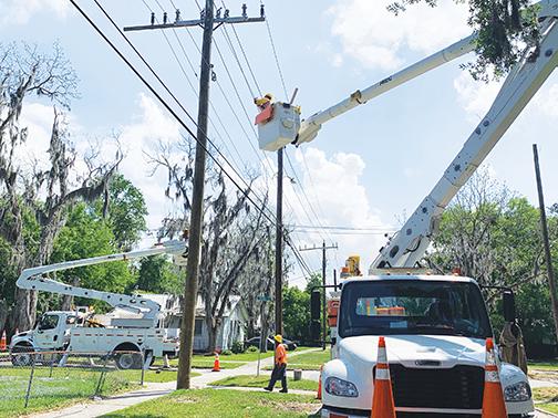 Florida Power & Light employees work on poles on South 15th Street in Palatka on Tuesday afternoon. The company will be checking poles throughout the county as part of its eight-year service cycle.