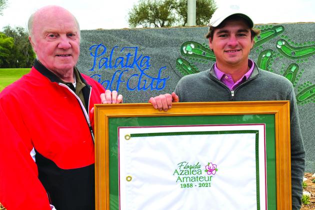Palatka Mens Golf Association president David Cox, left, presents 2021 Florida Azalea Amateur winner Tyler Hitchner of Tuscaloosa, Alabama with a framed flag commemorating the event. Hitchner shot 4-under and defeated Michael Mattiace of Jacksonville in a playoff on Sunday. (DANNY HOOD / Special To The Daily News)