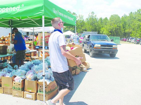 An Epic-Cure Putnam volunteer gathers boxes of food last May to give to families in need during the coronavirus pandemic.