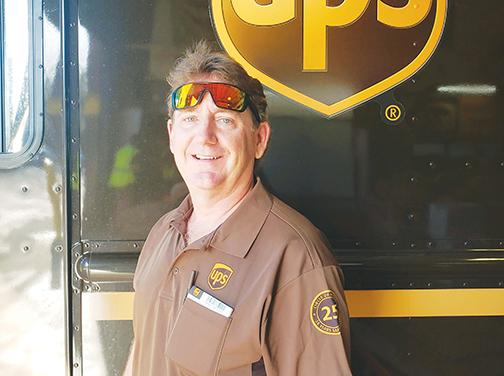 UPS driver Nick Johnson, who has a 25-year safe driving record, stands in front of his truck before his Palatka route.