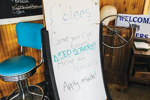 A sign at Colee’s Restaurant advertises the need for new employees, especially servers.