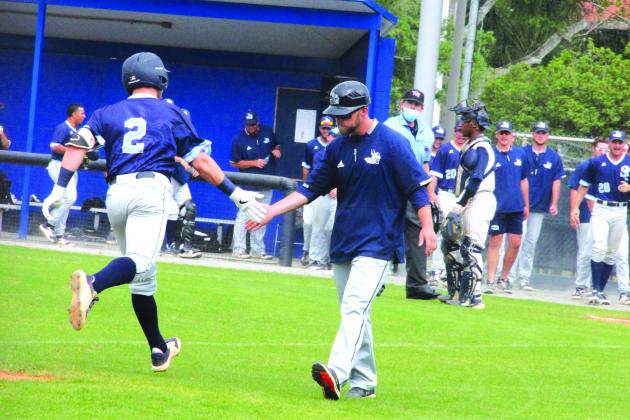 St. Johns River State’s Chase Malloy is congratulated by assistant coach Morgan Depew as he rounds third after his solo home run in the third inning. (ANTHONY RICHARDS / Palatka Daily News)