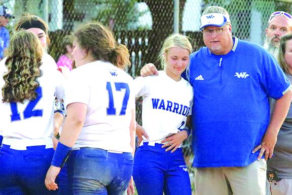 Peniel Baptist Academy softball coach Jeff Hutchins gives words of encouragement to shortstop-second baseman Brook Williams after the Warriors won the District 4-2A championship last week. (ANTHONY RICHARDS / Palatka Daily News)