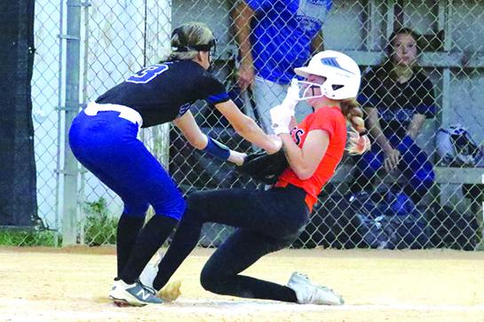 Peniel Baptist Academy’s Alexis Wallace (left) tags out Christ Church Academy’s Bella Brewer trying to score on a wild pitch in the third inning of Wednesday night’s regional game. (ANTHONY RICHARDS / Palatka Daily News)