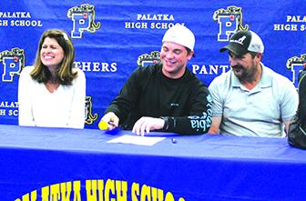 Flanked alongside mother, Ginger, and father, Tim, Palatka High School’s Lane Heuer is all smiles after signing his letter of intent to play at Nebraska Wesleyan on March 31. (MARK BLUMENTHAL / Palatka Daily News)