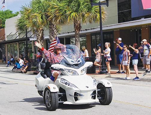 A patriotic Putnam County resident waves as she rides along the Memorial Day Parade in Palatka.