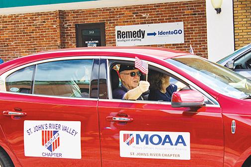 George Crawford represents the Military Officers Association of America as he rides along the Memorial Day Parade in Palatka on Monday.