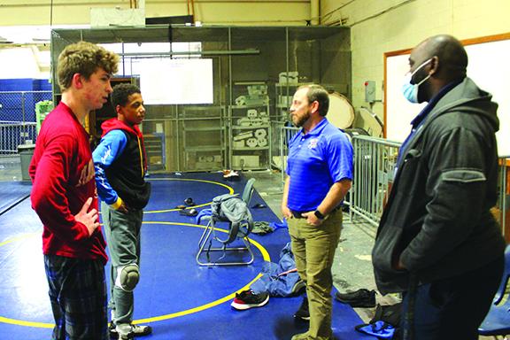Josh White (second from right) chats with state tournament wrestlers Brandon Lewis (left) and Mikade Harvey, while assistant coach Elisha Campbell listens at right during a practice in March. (MARK BLUMENTHAL / Palatka Daily News)