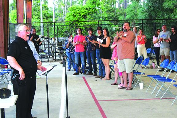 Longtime Peniel Baptist Academy athletic director, youth pastor and coach Terry Goodwin acknowledges the standing ovation he got Thursday night during the end-of-the-season sports banquet under the pavillion at the school. (MARK BLUMENTHAL / Palatka Daily News)