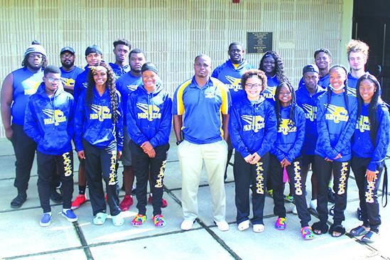 2021 Daily News Coach of the Spring Jarimy Passmore, center, is surrounded by those who helped make this season special. In the front row, from left, are Derick Holland, Khi’ya Lookadoo, Ja’Mya Douglas, Mikah Harvey, Ymira Passmore, Q’Juan Nelson, Al’leah Ford and Samiya Edwards. In the back row, from left, are James Matthews, assistant coach Kedric Wright, Johnathan Givens, Jashaun White, Jacques Fenderson, Daunte Wilkerson, Torryence Poole, Justus Curry and Seager Jordan. (MARK BLUMENTHAL / Daily News)