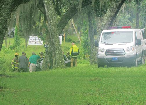 Law enforcement officials and emergency responders work the fatal crash scene off Crill Avenue in Palatka on Friday morning.