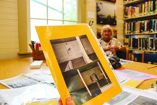 Linda Bazar, a member of Friends of Bostwick Library, watches as residents look at old photos Wednesday from when the Bostwick Library started to be refurbished.
