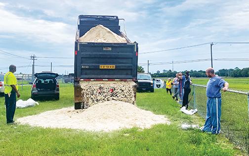 A Putnam County Public Works Department truck dumps sand at the East Palatka Commmunity Park on Tuesday as residents fill bags of sand to prepare for Tropical Storm Elsa.