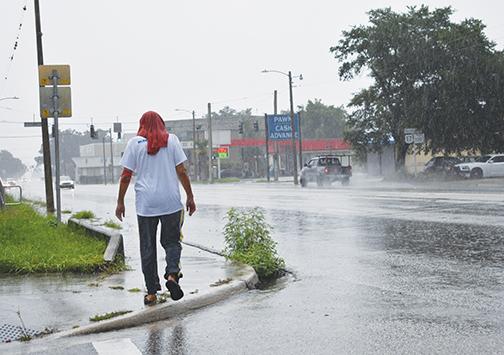 A local man traverses down Reid Street in Palatka as Tropical Storm Elsa lashes Putnam County on Wednesday.