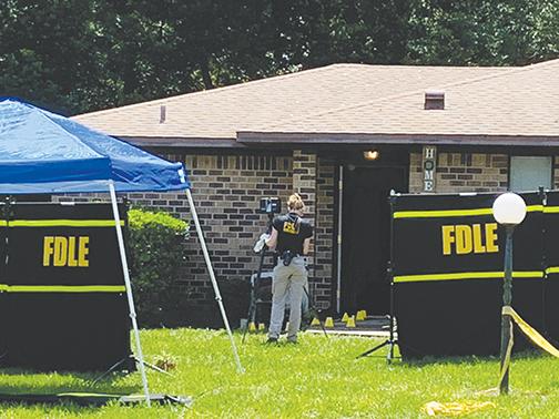 A Florida Department of Law Enforcement technician works the site of a fatal shooting in Crescent City.