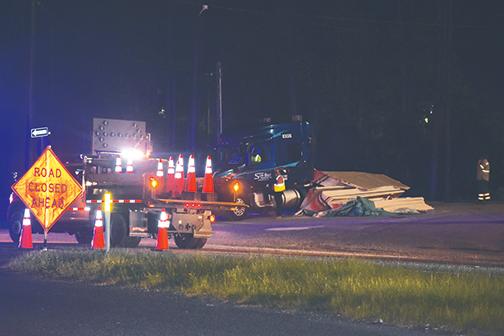 Workers block traffic on U.S. 17 after a train crashed into a tractor-trailer at the railroad crossing leading to Seminole Electric and Saint-Gobain Corp. just north of Palatka on Thursday.