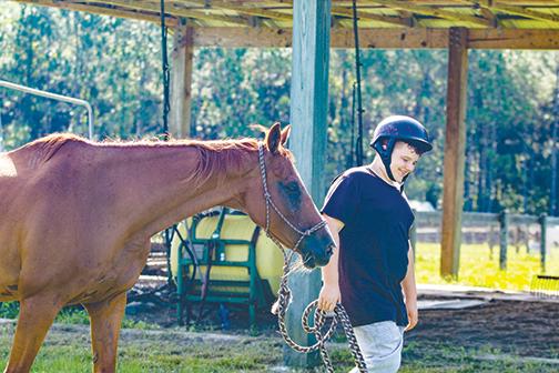 Jonathan Hall, 14, leads his horse, Trooper, to a pen at Rodeheaver Boys Ranch to train the 1,300-pound thoroughbred as part of the ranch’s new vocational program.