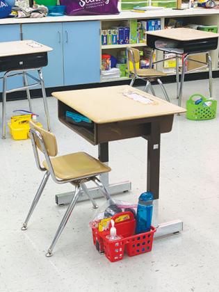 Sanitizing supplies are stationed near students’ desks.