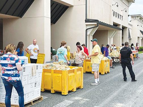 Volunteers wait to provide food to residents during a June 19 Farm Share giveaway at the Putnam County Government Complex in Palatka.