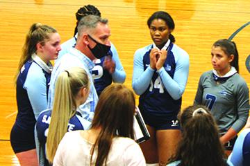 Dariana Luna (7) listens in on St. Johns River State College volleyball coach Matt Cohen during a timeout in the team’s opening match of the season against Florida State College-Jacksonville in February. (MARK BLUMENTHAL / Palatka Daily News)