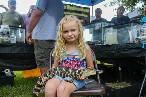 Serena Crawford was a little nervous to hold Puppy the Alligator on Sunday but she does not show it as she poses for a photo during Fourth of July celebrations in Palatka.