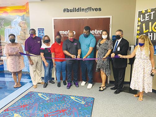 T-Mobile mobile event expert Stephon Smallwood cuts the ribbon at the Mellon Learning Center Monday morning.