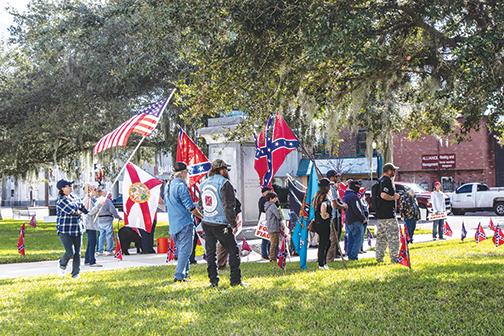A crowd of people in December 2020 protest efforts to remove the Confederate monument from the Putnam County Courthouse lawn.
