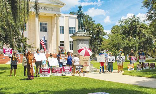 Protesters gather in front of the Confederate monument at the Putnam County Courthouse on Saturday as they advocate the relocation of the statue. 