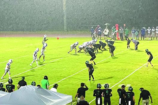 Interlachen Jr.-Sr. High quarterback Reggie Allen Jr. (top left) calls signals for his offense during a pounding rainstorm in the second quarter Friday night against host Daytona Beach Father Lopez. (TYLER JARNIGAN / Special to the Daily News)