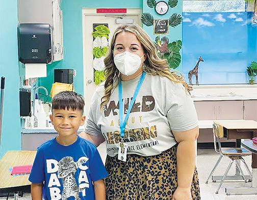 A student and teacher at Browning-Pearce Elementary School greet each other last week on the first day of classes. 