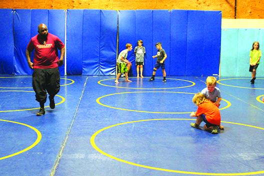 Palatka High School assistant wrestling coach and former state champion Elysha Campbell watches over younger wrestlers during the final day of camp that has run since May on Thursday in the PHS wrestling room. (MARK BLUMENTHAL / Palatka Daily News)