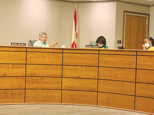 Putnam County School District board member David Buckles has a back-and-forth exchange with parent Samantha Robinson, right, during Tuesday’s board meeting.