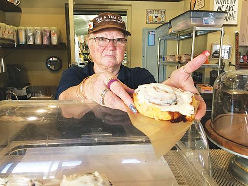 Lou Singleton, the owner of This and That Café, serves one of her fresh-baked cinnamon rolls.