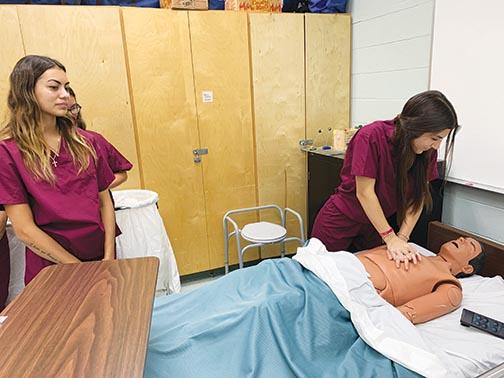Melanie DeLeon, the Health Occupations Students of America program president at Crescent City Junior-Senior High, practices CPR on a mannequin.