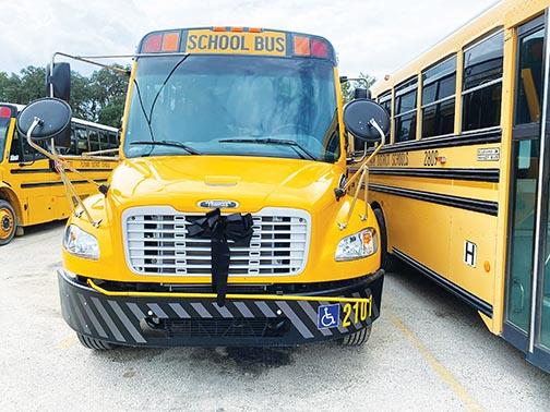A school bus at the Putnam County School District depot bears a black ribbon in honor of Retha Ann Padgett, a bus driver who died from COVID complications.