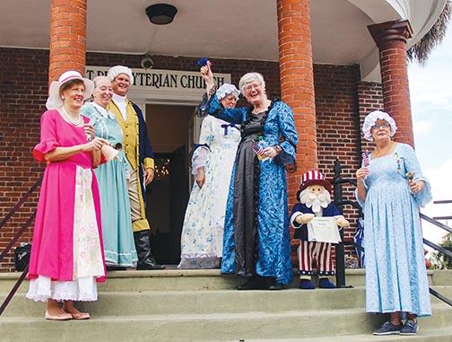 Members of the William Bartram Chapter of the National Society of the Daughters of the American Revolution ring bells as they stand by George Washington on Friday in Palatka to celebrate Constitution Week. 