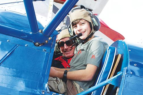 A child sits in the cockpit of a vintage plane during the 2020 Fly-in and Classic Car Show.