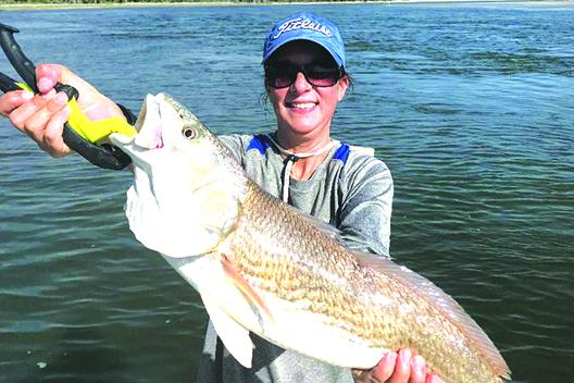 Ana Heartz holds up her 37-inch redfish before  releasing back into the waters recently. (GREG WALKER / Daily News correspondent)