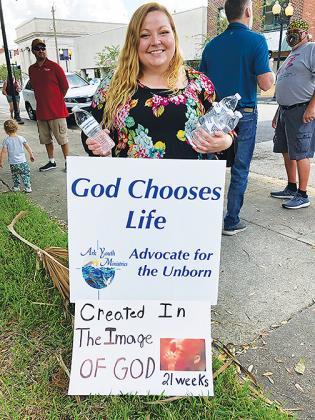 St. Augustine resident Kristin Maisenhelder distributes water during Saturday’s march, where she supported the pro-life stance.