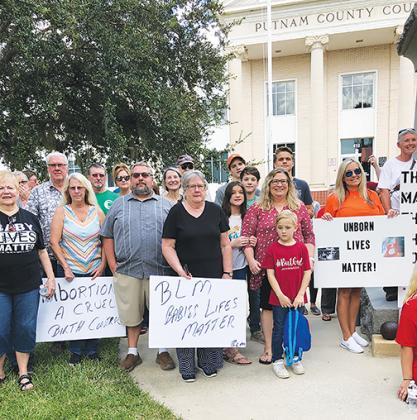 Organized by County Commissioner Paul Adamczyk, pictured in the blue shirt, a group of residents gathers to protest in support of stricter abortion laws.