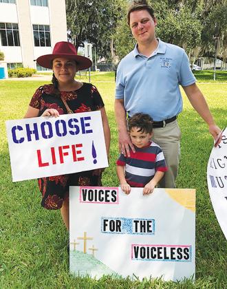 Pastor Robert Bush of Faith Baptist Church in Palatka attends a pro-life prayer rally in downtown Palatka with his wife and son.