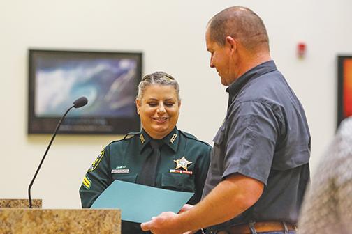 DeLoach presents Cpl. Threasa Owens with the Sheriff’s Commendation Award during the Board of County Commissioners meeting Tuesday.