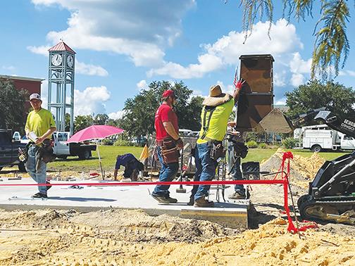 Workmen from Wilkinson Family Construction place a column support in place at the new Palatka amphitheater under construction on the riverfront near the Millennium Clock Tower.