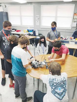 Q.I. Roberts Junior-Senior High School students tinker with one of the robots they made.