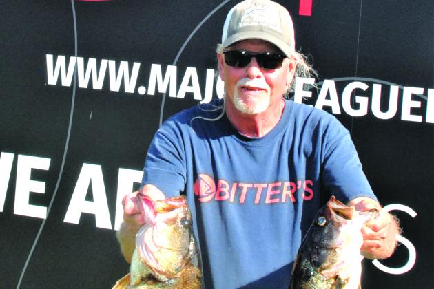 First place co-angler Kenneth Hunnicutt holds up two of his five fish creel Friday. (GREG WALKER / Daily News correspondent)